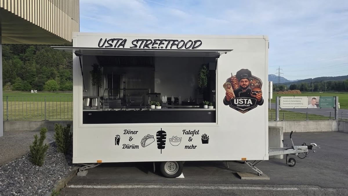 Der weiße Foodtruck von USTA Streetfood mit offener Klappe, Logo und Schriftzug