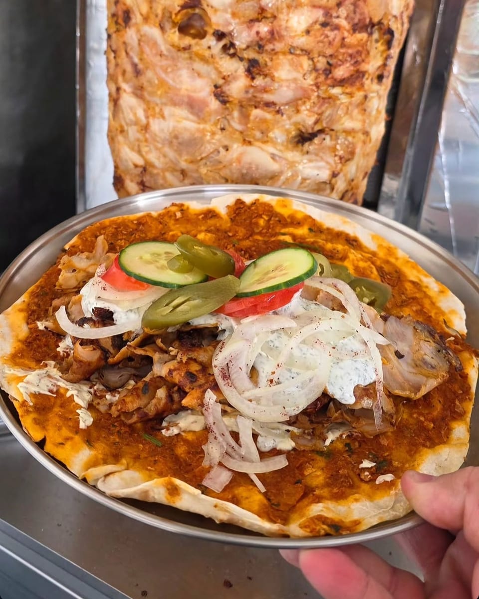Lahmacun mit Kebabfleisch, Zwiebeln, Gurke, Tomate und Jalapeños auf dem Teller