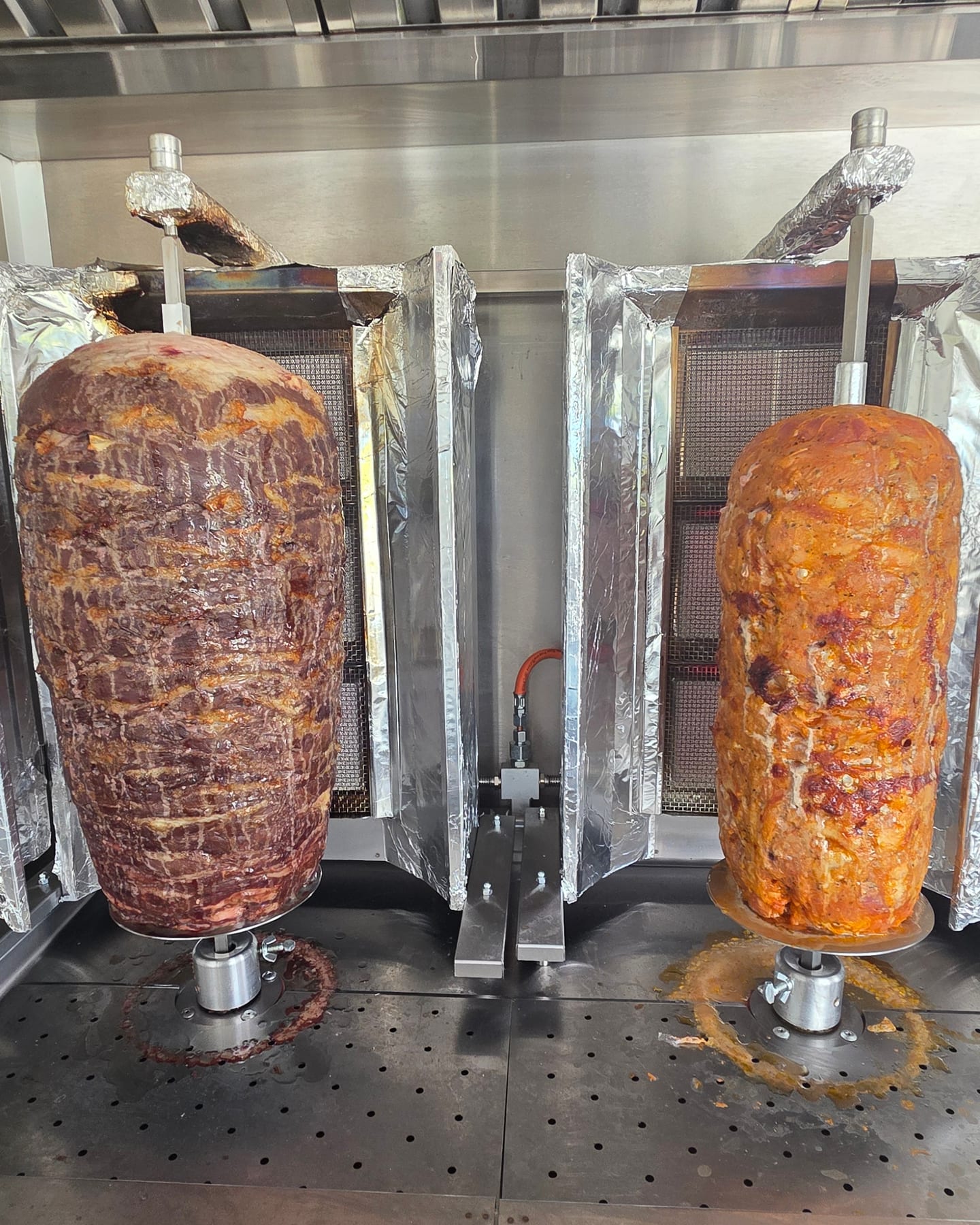 Zwei Dönerspieße im Truck, links dunkles Fleisch, rechts Hähnchen